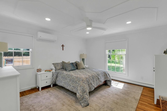 bedroom with ceiling fan, an AC wall unit, multiple windows, and light hardwood / wood-style flooring