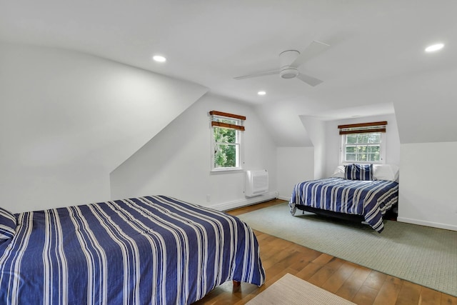 bedroom featuring hardwood / wood-style floors, a wall mounted air conditioner, lofted ceiling, a baseboard heating unit, and ceiling fan