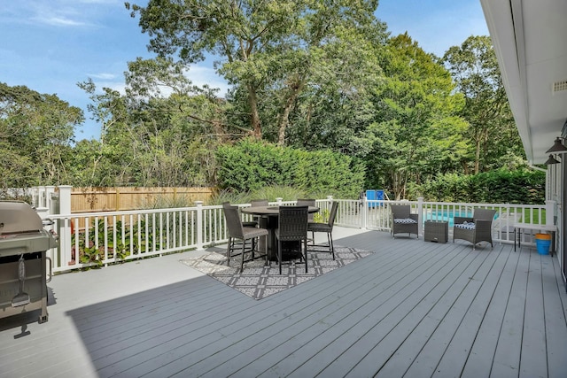 wooden terrace featuring grilling area and an outdoor living space