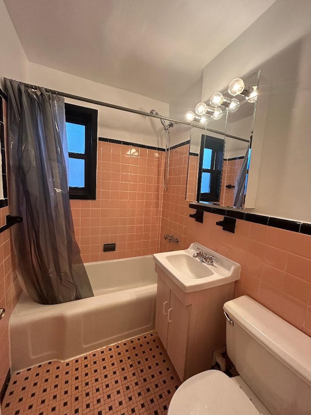 full bathroom with vanity, tile patterned flooring, toilet, shower / bathtub combination with curtain, and tile walls