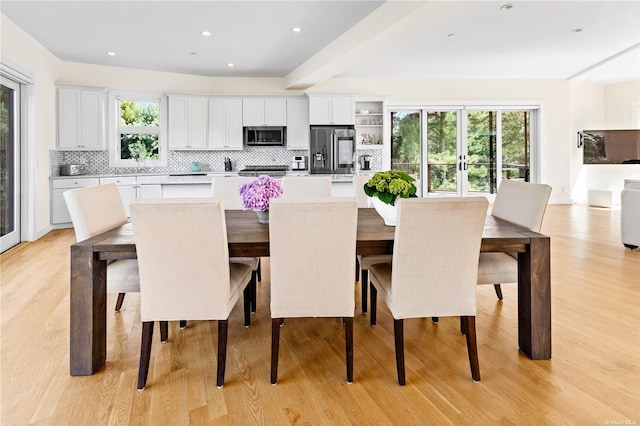 dining area featuring light wood-type flooring and french doors