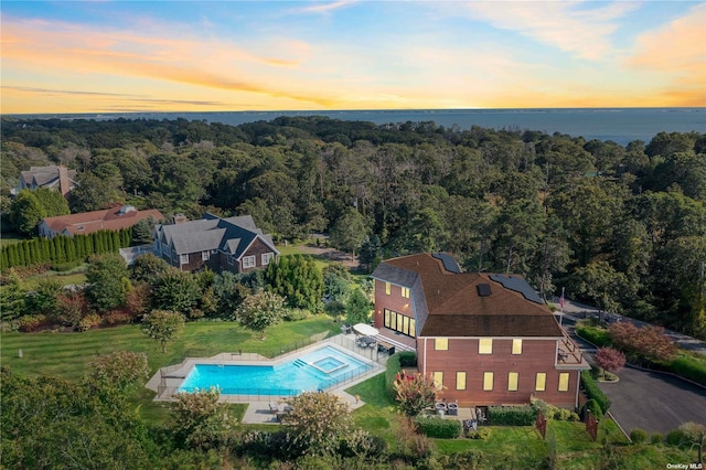 aerial view at dusk featuring a water view