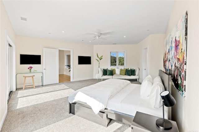 bedroom with light colored carpet, ceiling fan, and ensuite bathroom