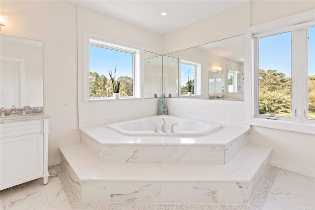 bathroom featuring vanity, a wealth of natural light, and tiled tub