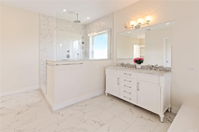 bathroom with a tile shower and vanity