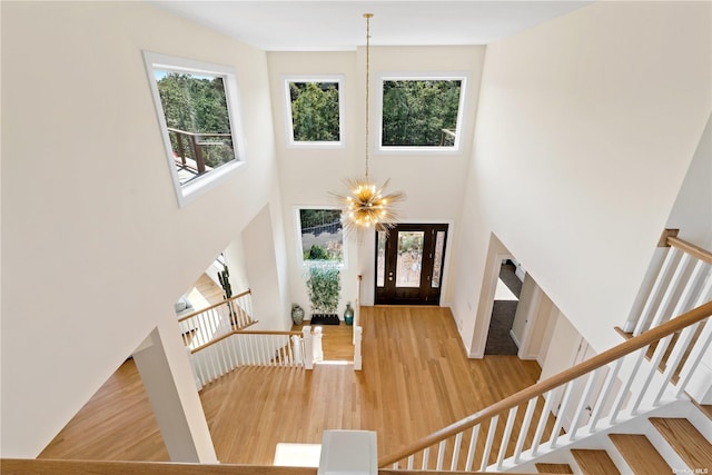 entryway featuring hardwood / wood-style floors, a high ceiling, and an inviting chandelier