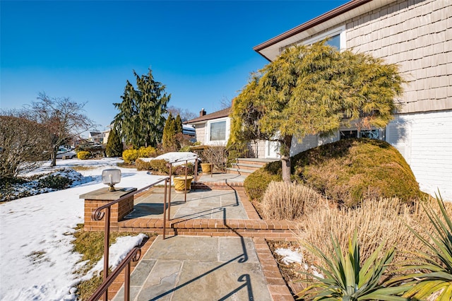 yard layered in snow featuring a patio area