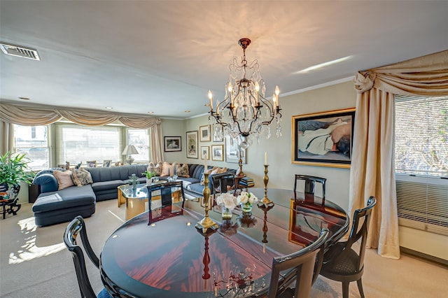 carpeted dining room featuring ornamental molding and a chandelier