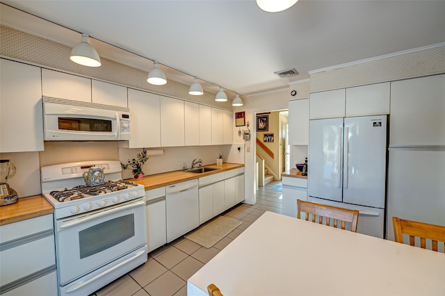 kitchen with white cabinetry, sink, white appliances, and light tile patterned flooring