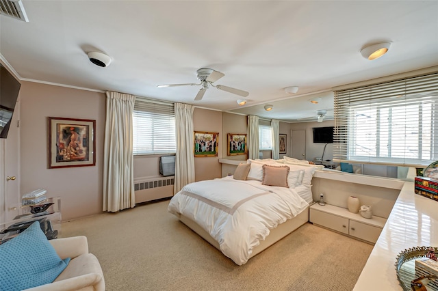 carpeted bedroom featuring crown molding, ceiling fan, radiator, and multiple windows