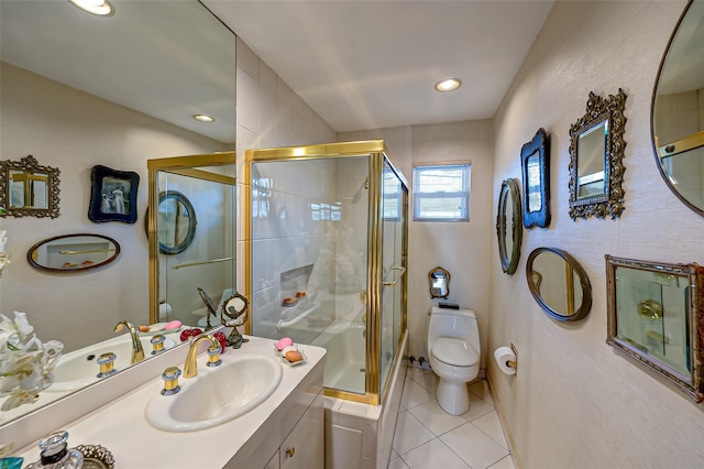 bathroom featuring vanity, a shower with door, tile patterned floors, and toilet