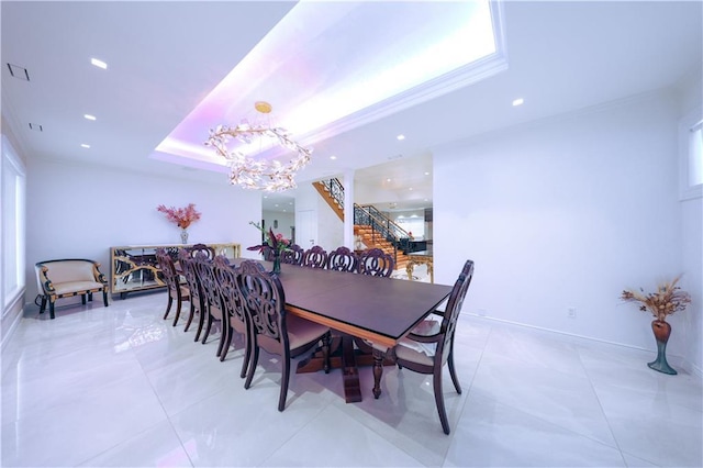 tiled dining space featuring a chandelier, crown molding, and a tray ceiling