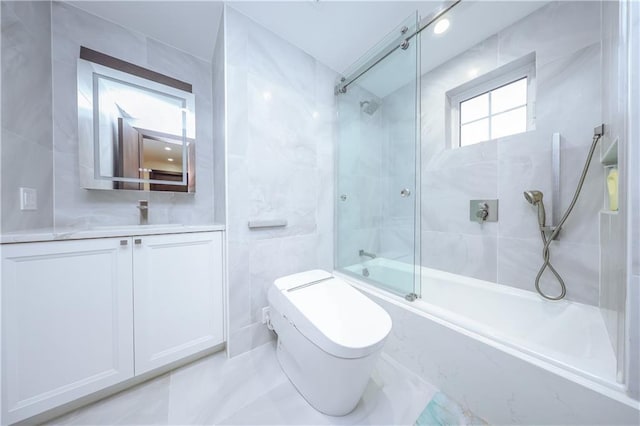 full bathroom featuring toilet, vanity, tile walls, and combined bath / shower with glass door