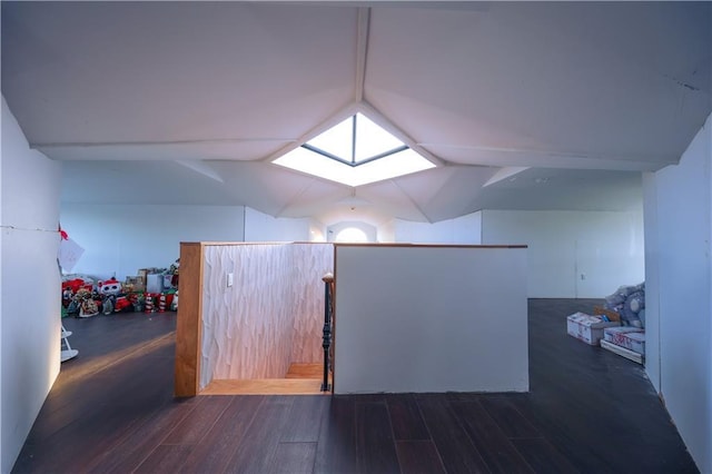 bonus room featuring vaulted ceiling with skylight and dark wood-type flooring