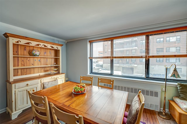 dining room featuring ornamental molding, wood-type flooring, and radiator