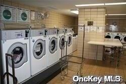 clothes washing area with tile patterned floors and washer and clothes dryer