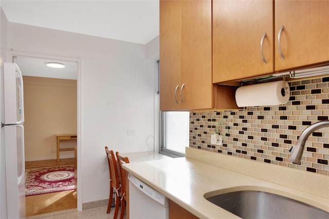 kitchen with decorative backsplash, sink, white appliances, and built in desk