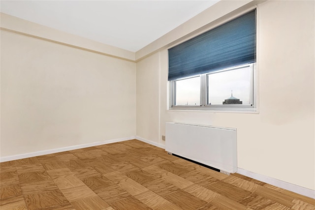 unfurnished room with light parquet floors and radiator