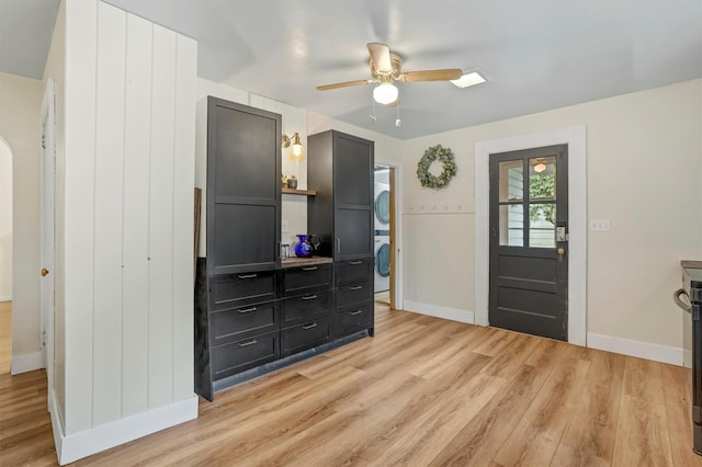 entryway featuring light wood-type flooring, ceiling fan, and stacked washer and clothes dryer