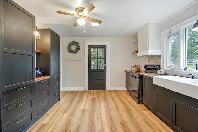 kitchen with light wood-type flooring, ceiling fan, black / electric stove, and tasteful backsplash