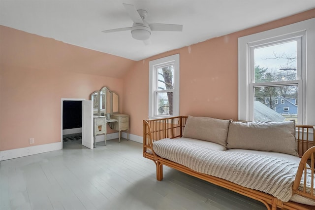 living area with ceiling fan, light hardwood / wood-style floors, and vaulted ceiling