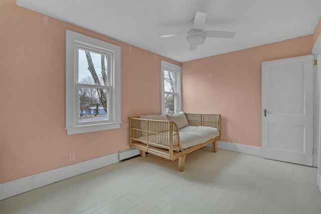 living area featuring ceiling fan and a baseboard radiator