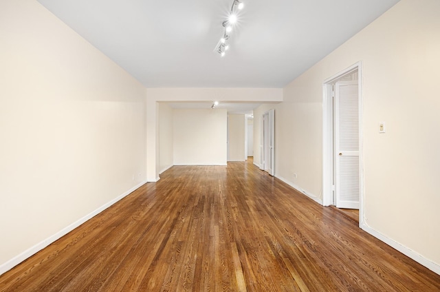 unfurnished room featuring wood-type flooring and track lighting