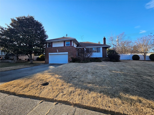 tri-level home with a front yard and a garage