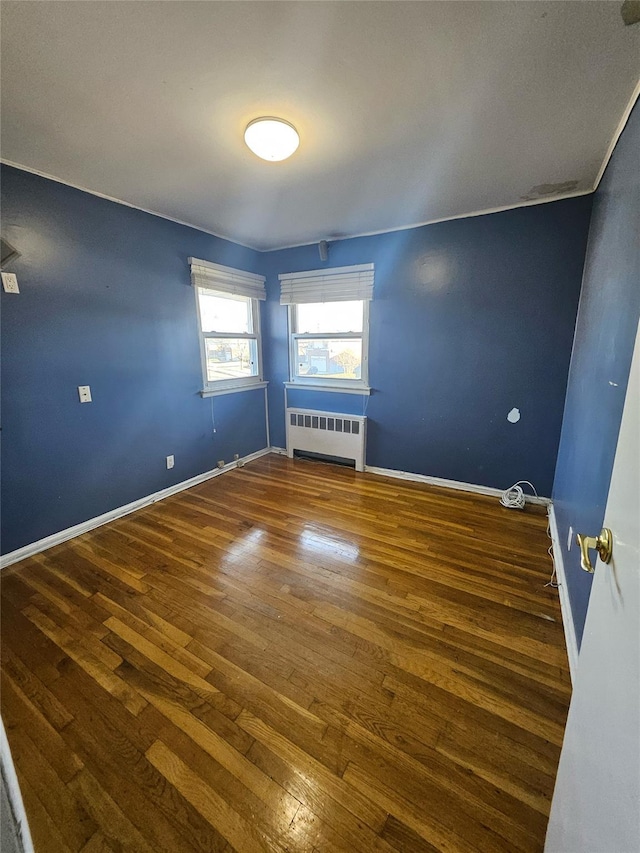 unfurnished room with hardwood / wood-style floors and radiator