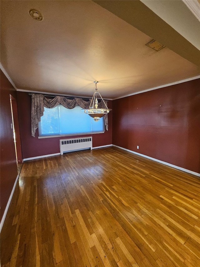 unfurnished dining area with hardwood / wood-style flooring, radiator heating unit, and crown molding