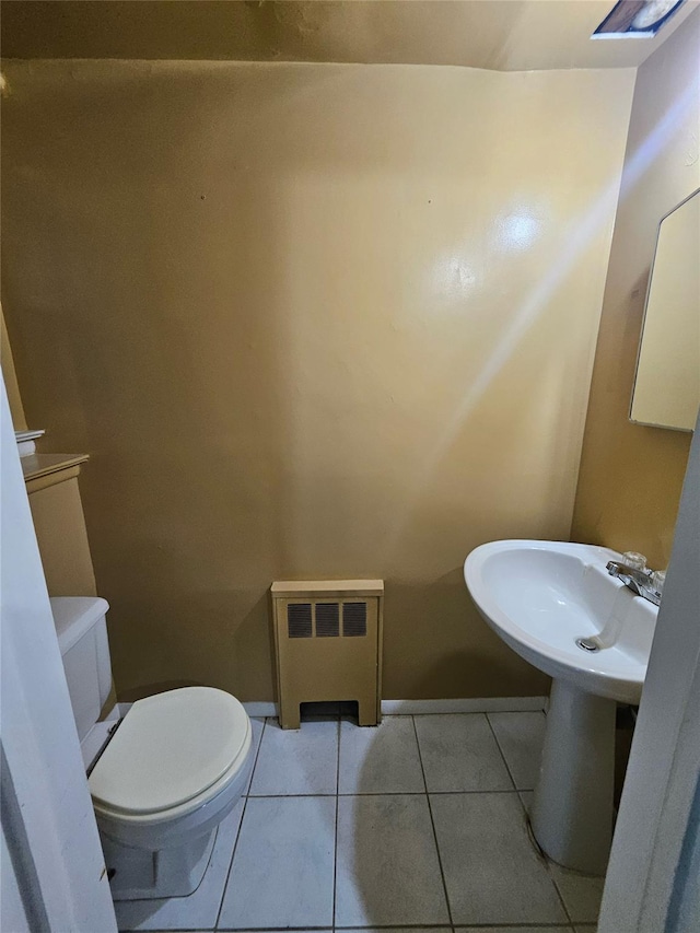 bathroom with tile patterned flooring, toilet, radiator heating unit, and sink