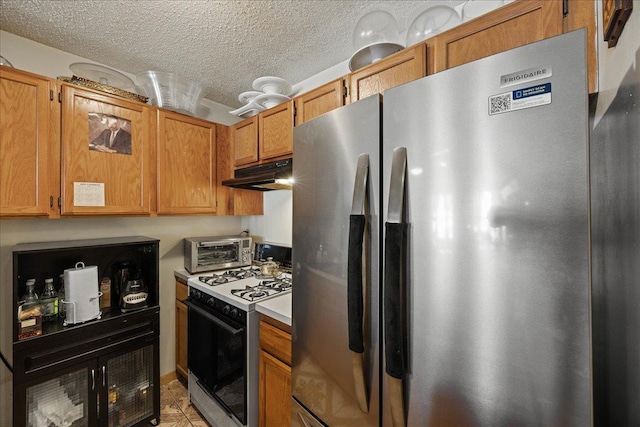 kitchen featuring stainless steel fridge with ice dispenser, light tile patterned flooring, white range with gas stovetop, and a textured ceiling