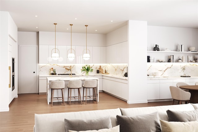 kitchen featuring white cabinets, decorative light fixtures, decorative backsplash, and a breakfast bar