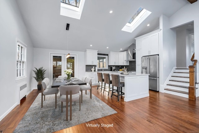 dining area featuring radiator, vaulted ceiling, and dark hardwood / wood-style floors