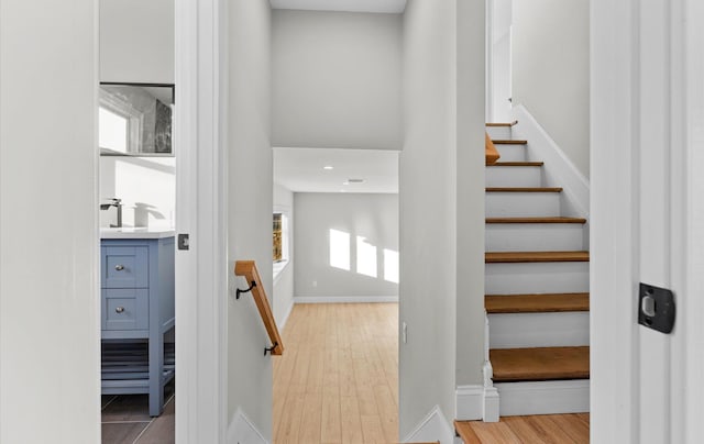 stairs with sink and hardwood / wood-style flooring