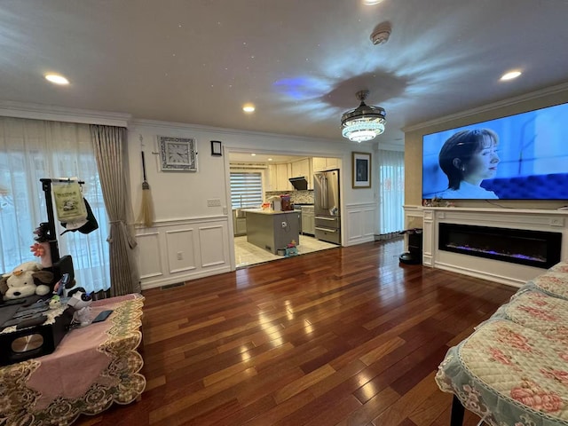 living room with ornamental molding and dark hardwood / wood-style floors