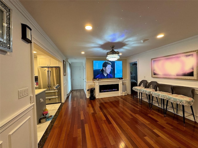 home theater room featuring ornamental molding and wood-type flooring