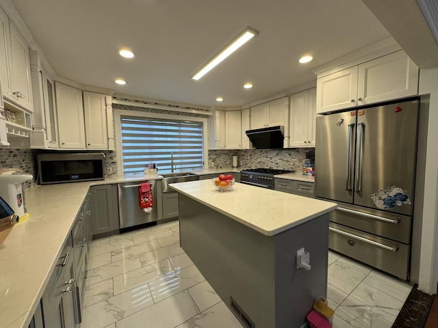 kitchen with white cabinets, gray cabinetry, a center island, high quality appliances, and sink