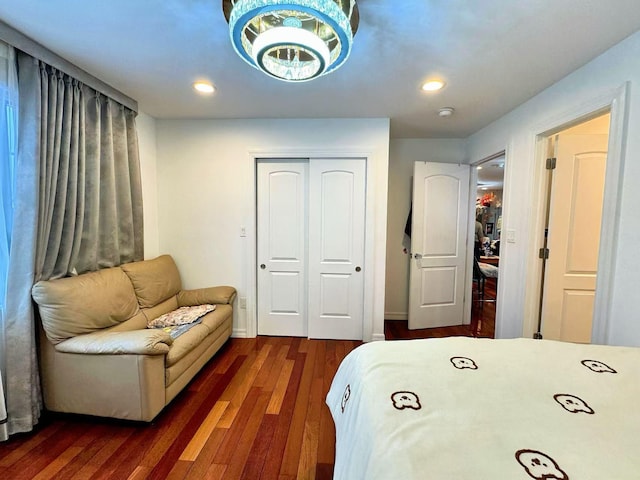 bedroom featuring a closet, an inviting chandelier, and dark wood-type flooring