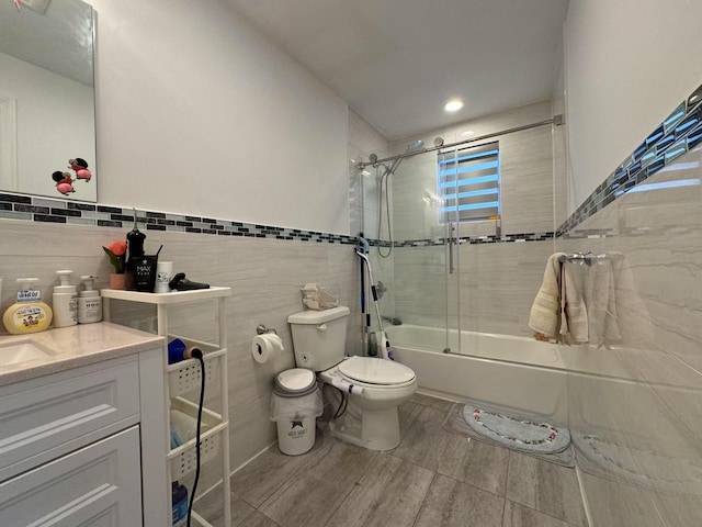 full bathroom with toilet, enclosed tub / shower combo, and vanity