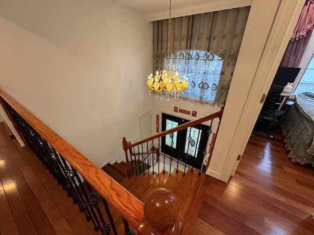 staircase featuring a chandelier and hardwood / wood-style floors