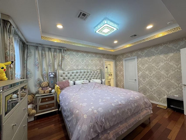 bedroom with a tray ceiling and dark hardwood / wood-style floors