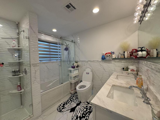 full bathroom featuring toilet, combined bath / shower with glass door, tile walls, an inviting chandelier, and vanity