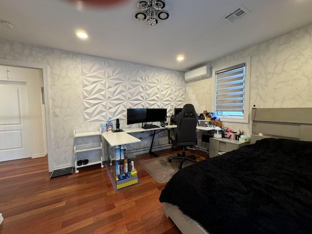 bedroom featuring a wall mounted air conditioner and dark hardwood / wood-style flooring