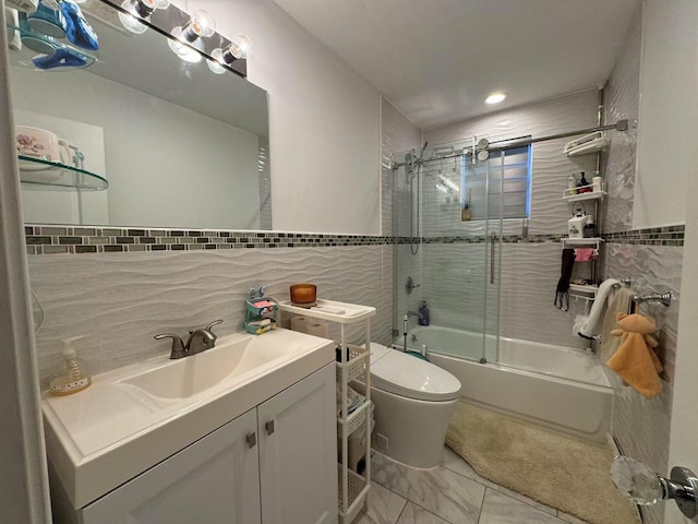 full bathroom featuring toilet, combined bath / shower with glass door, vanity, tile walls, and decorative backsplash