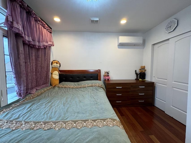 bedroom featuring dark hardwood / wood-style flooring, a wall mounted air conditioner, and a closet