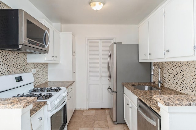 kitchen featuring tasteful backsplash, dark stone countertops, sink, appliances with stainless steel finishes, and white cabinets