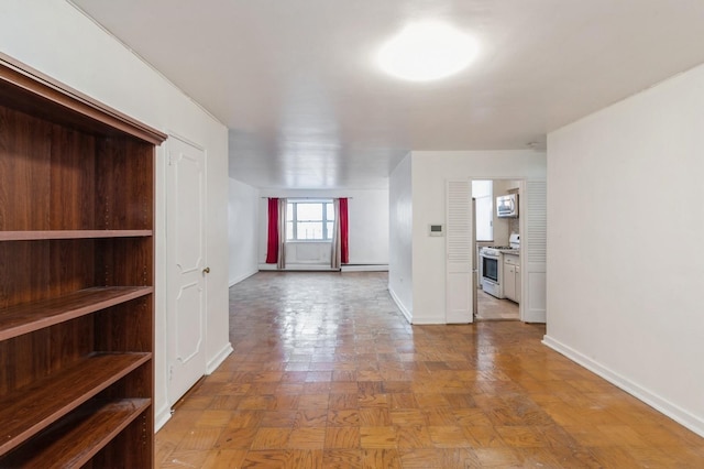 interior space with light parquet flooring and a baseboard heating unit