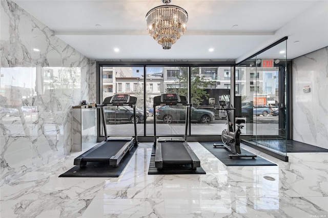 workout area featuring a notable chandelier, expansive windows, and tile walls