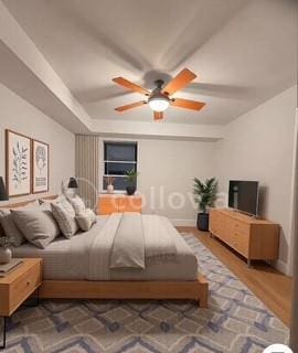 bedroom with a raised ceiling and hardwood / wood-style flooring